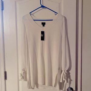 White tunic with sheer sleeves and tie wrist detail.